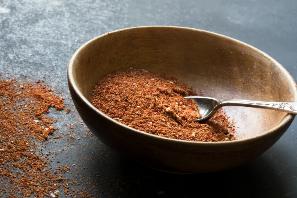 Homemade taco seasoning ingredients in small bowls: chili powder, cumin, garlic powder, paprika, and onion powder, ready to be mixed into a flavorful taco seasoning blend.