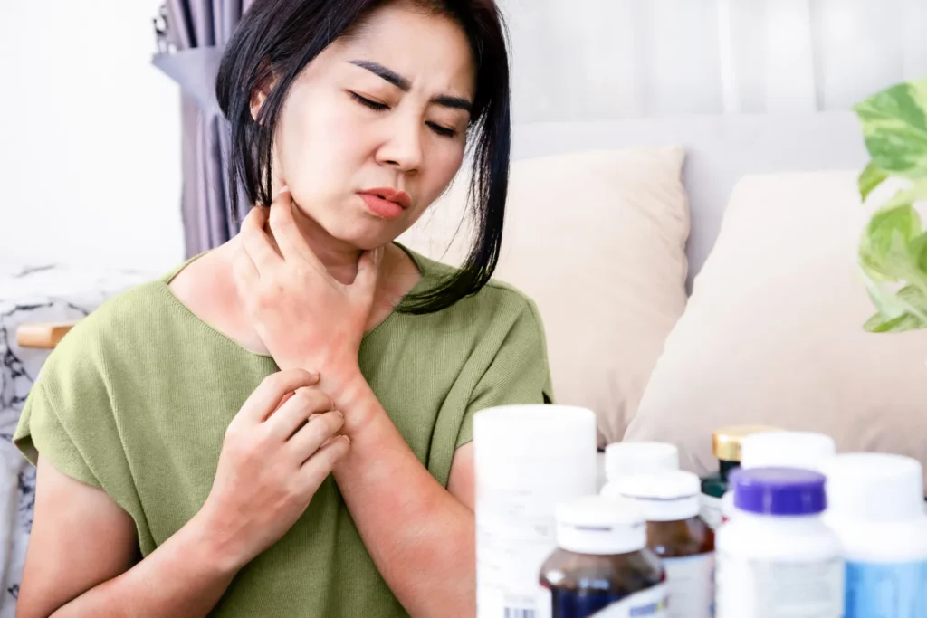 Person showing signs of an allergic reaction, such as skin rash, next to an okra pod.